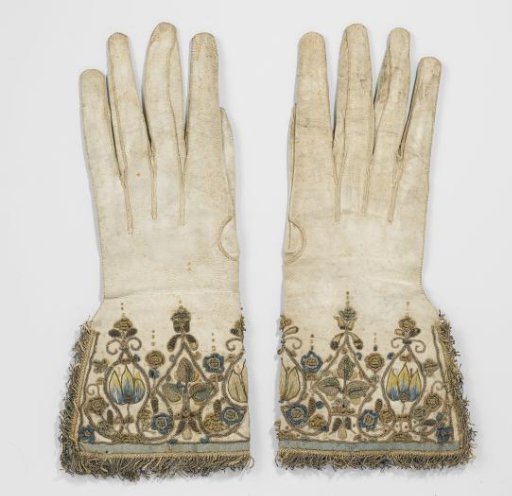 Glove of white sheepskin with attached cuffs embroidered with floral motifs in blue, yellow and pink silk and metal cording, trimmed with gold fringe