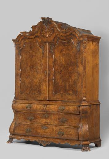 Mahogany cabinet, decorated with carved sections and rocaille motifs. Upper cabinet with two doors; lower cabinet double-arched with four drawers.
