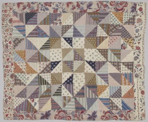 Patchwork quilt of sewn-together triangles of colorful cotton, bordered with eighteenth-century chintz. Lining of printed cotton with flowers in red and brown on a dotted ground