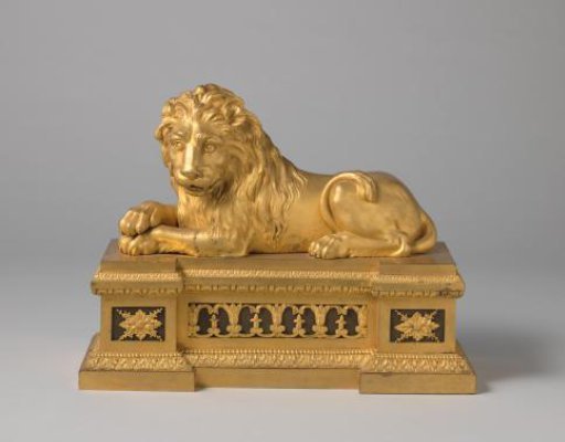 Fire dog of gilded bronze in the form of a recumbent lion on a base