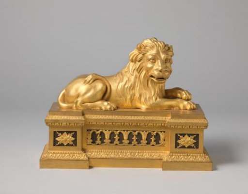 Fire dog of gilded bronze in the form of a recumbent lion on a base