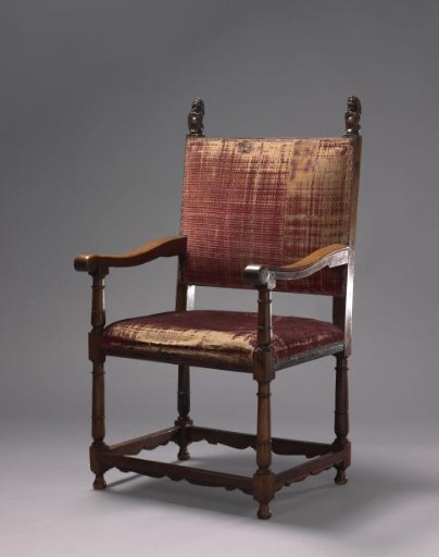 Armchair with stiles crowned by seated lions bearing shields. Upholstered in red velvet.