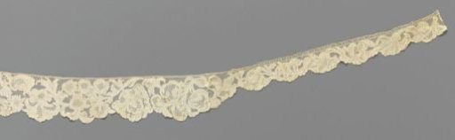 Cuff of needle lace with a symmetrical pattern with a flower vase, vines with feathered leaves and irises