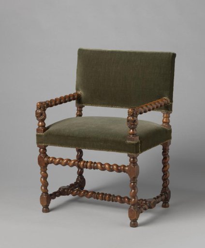 Walnut armchair with scrolled elements. Armrest supports with half-figures of women. Upholstered in studded velvet.