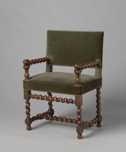 Walnut armchair with scrolled elements. Armrest support with a female bust on a vase-shaped round pedestal. Upholstered in studded velvet.