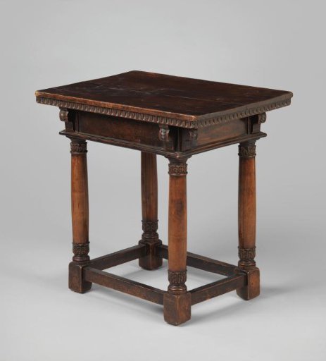 Table on four columns connected by rails with foliate decoration. In the front rail a drawer with a handle.