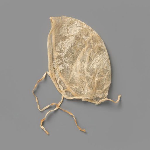Children's cap of white tulle, with white embroidered leaf and flower vines and at the back a star-shaped motif