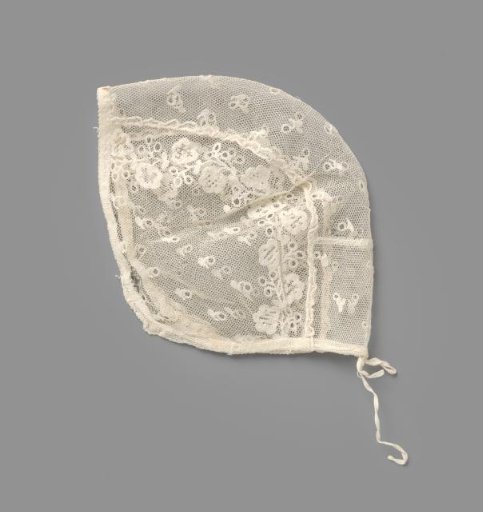 Children's cap of white tulle with white embroidery, showing a scattering motif and flower vines on either side of the center