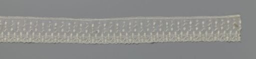 Strip of needle lace with S-shape in scatter motif