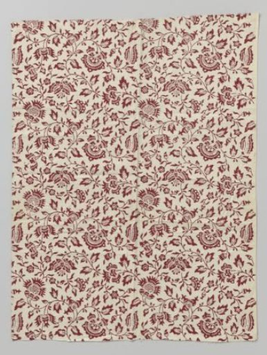 Fragment of red printed cotton with an asymmetrical pattern of butterfly-shaped flowers