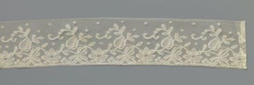 Strip of bobbin lace with rosette flower between heart-shaped leaves and vine leaves