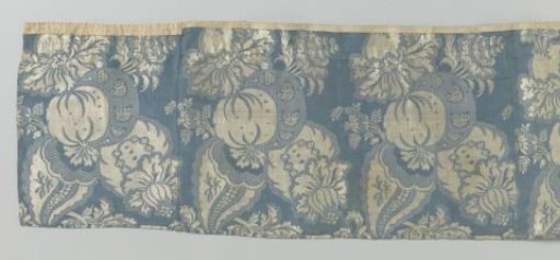 Fragment of a silk weave with a pattern of a large bouquet and pomegranate in white on blue, a so-called mosaic decoration