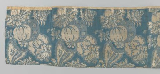 Fragment of a silk weave with a pattern of a large bouquet and pomegranate in white on blue, a so-called mosaic decoration