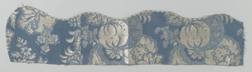 Fragment of a silk weave with a pattern of a large bouquet and pomegranate in white on blue, a so-called mosaic decoration