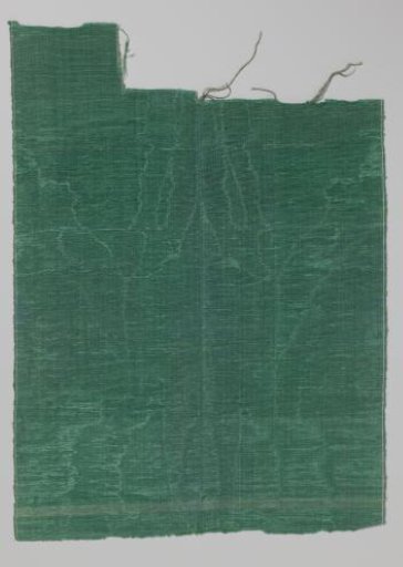 Fragment of silk with a symmetrically watered pattern in emerald green
