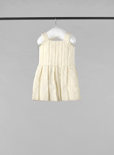 Sleeveless Child's Dress or Monkey Coat of White Waffle Piqué with Bodice of Stitched-Down Flat Pleats and Back Closure with Three Bows