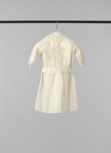 Apron or dress for a child of sturdy white cotton twill with woven stripe