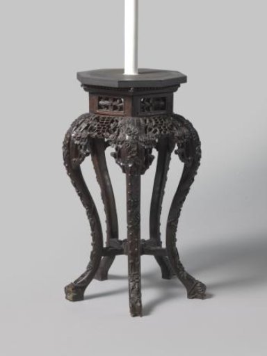 Table with hexagonal top and base, on S-shaped legs, decorated with floral and leaf motifs