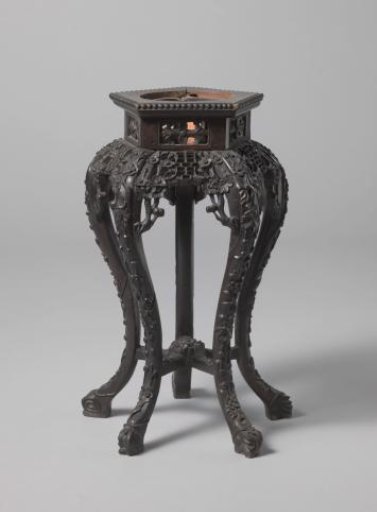 Table with hexagonal top and base, on S-shaped legs, decorated with floral and leaf motifs