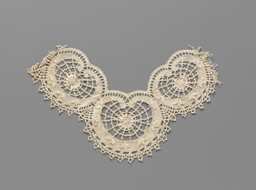 Neck ornament of coarse bobbin lace with three linked kidney-shaped frames with a flower with leaves in outline in the center