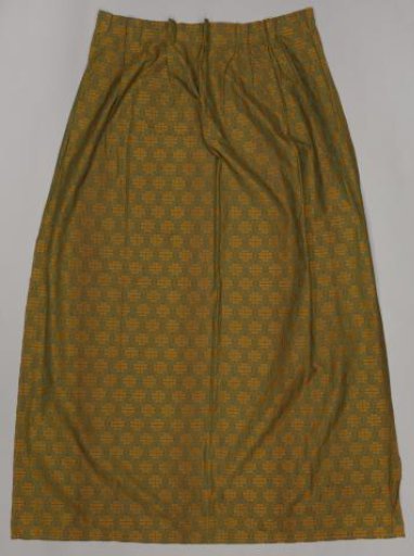 Curtain with a pattern of leaves within pointed ovals in yellow on a green ground