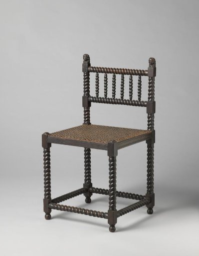 Chair with a Woven Rattan Seat, Stiles of the Backrest Surmounted by Carved Heads