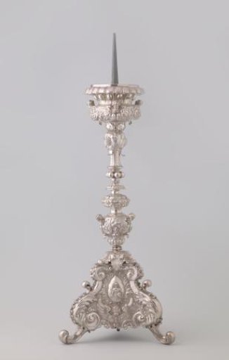 Silver candelabrum with five-part segmented baluster stem on triangular foot on volute feet. Decorated with three medallions with Christ, Peter, and Ignatius