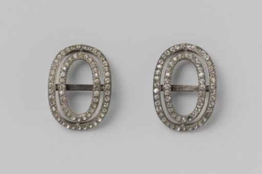 Brooch of strass set in a double oval silver-colored mount