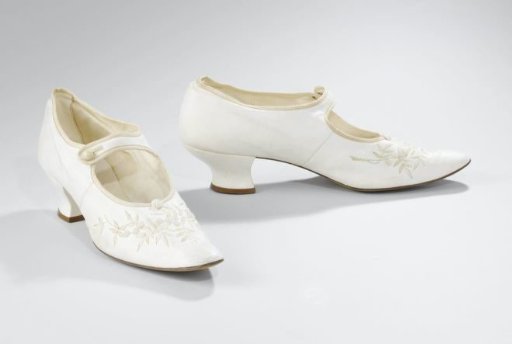 Bride's shoe of white glazed leather, with embroidered cream branches and white-beaded flowers on the upper; rounded very pointed toe, Pompadour heel covered with leather; instep strap