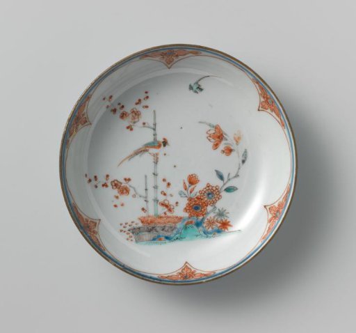 Saucer-dish with lotus scrolls and a pheasant on a prunus spray near flowering plants