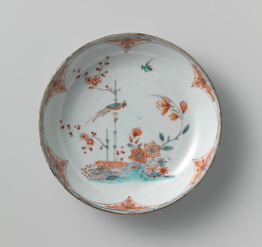 Saucer-dish with lotus scrolls and a pheasant on a prunus spray near flowering plants