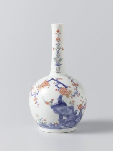 Bottle vase with flowering plants near rocks