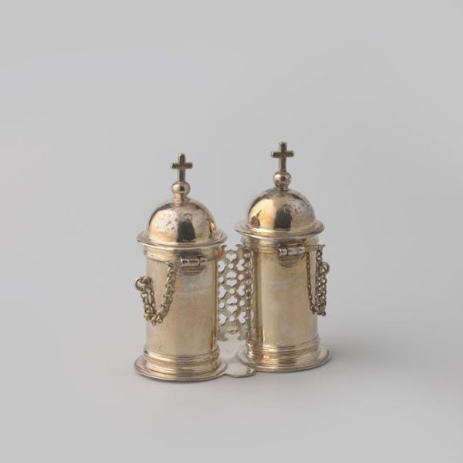 Chrismatorium, consisting of two cylindrical drums, attached to a three-lobed shield. Domes on the lids crowned with globe and cross.