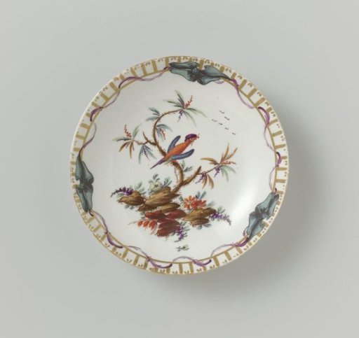 Dish, polychrome painted with a bird on a branch on a ground and border decoration of gold braid and vertical stripes, wrapped with a leaf garland