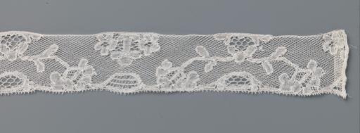 Strip of bobbin lace with an arch of branches from a triangular cartouche