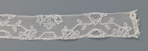 Strip of bobbin lace with an arch of branches from a triangular cartouche