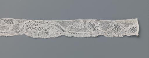 Strip of bobbin lace with intersecting motifs including leaves