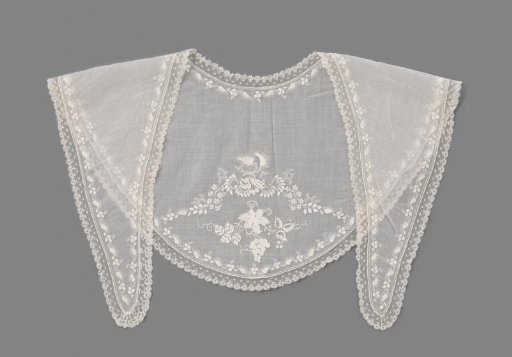 Fichu of linen batiste, embroidered on the back with a grapevine with grapes and vines in plumetis of white cotton, within a floral border and edged all around with a ruffled strip of Mechelen lace