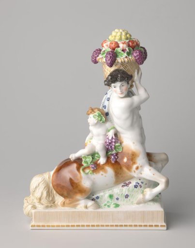 Figure in the shape of a centaur holding a fruit basket and carrying a boy on its back