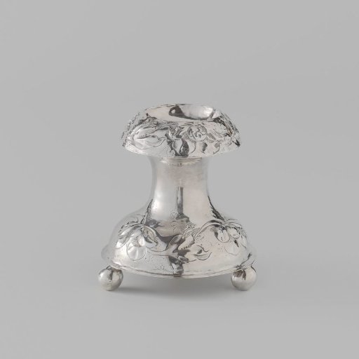 Salt cellar in the shape of a devil on an arched foot with three ball feet. Foot and rim with chased flowers and leaves.
