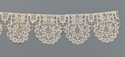 Strip of bobbin lace with seven-lobed flower in eleven-lobed shell