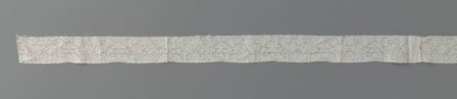 Strip of bobbin lace with symmetrical compositions composed of small floral motifs