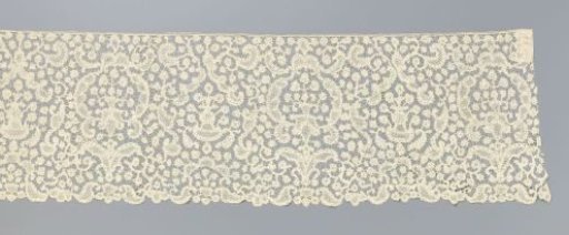 Strip of bobbin lace with symmetrical compositions with flower vases