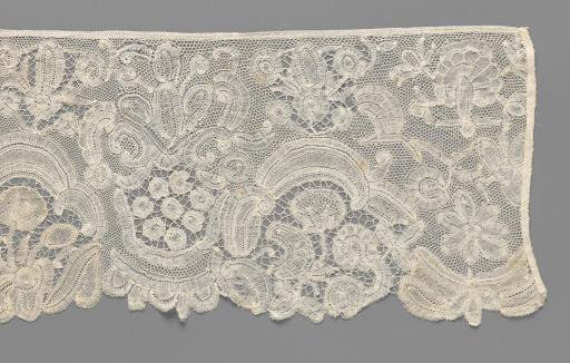 Strip of bobbin lace with various flowers and arches