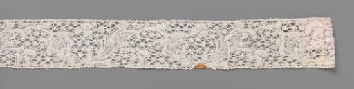 Strip of bobbin lace with curved flower stem with plume-shaped flower