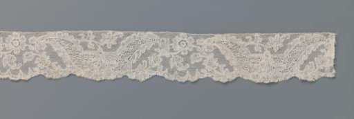 Strip of bobbin lace with a carnation in a U-shaped reserve