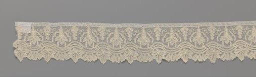 Strip of needle lace with wavy ornamental border and grape leaves