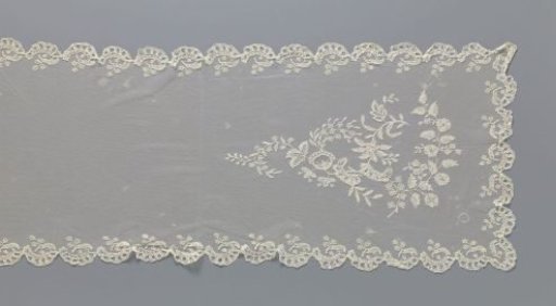 Scarf of appliqué lace with conical configuration of flower branches at the ends