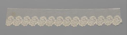 Strip of bobbin lace with ovals formed by curved leaves