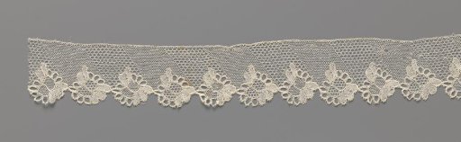 Strip of bobbin lace with flowers under diagonal bands in tulle ground and rose ground